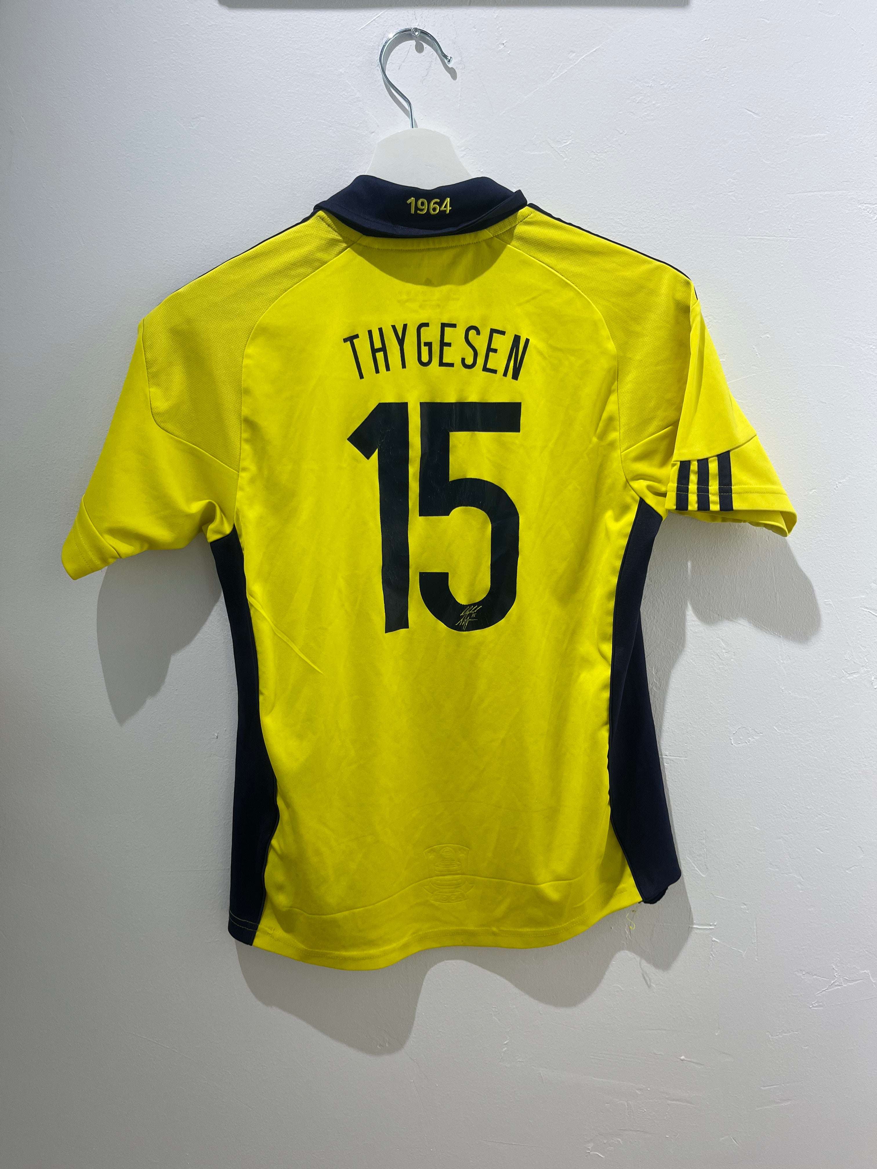 Bagsiden af en gul Thygesen Brøndby hjemme 2010/12 164 cm fodboldtrøje med nummer 15.