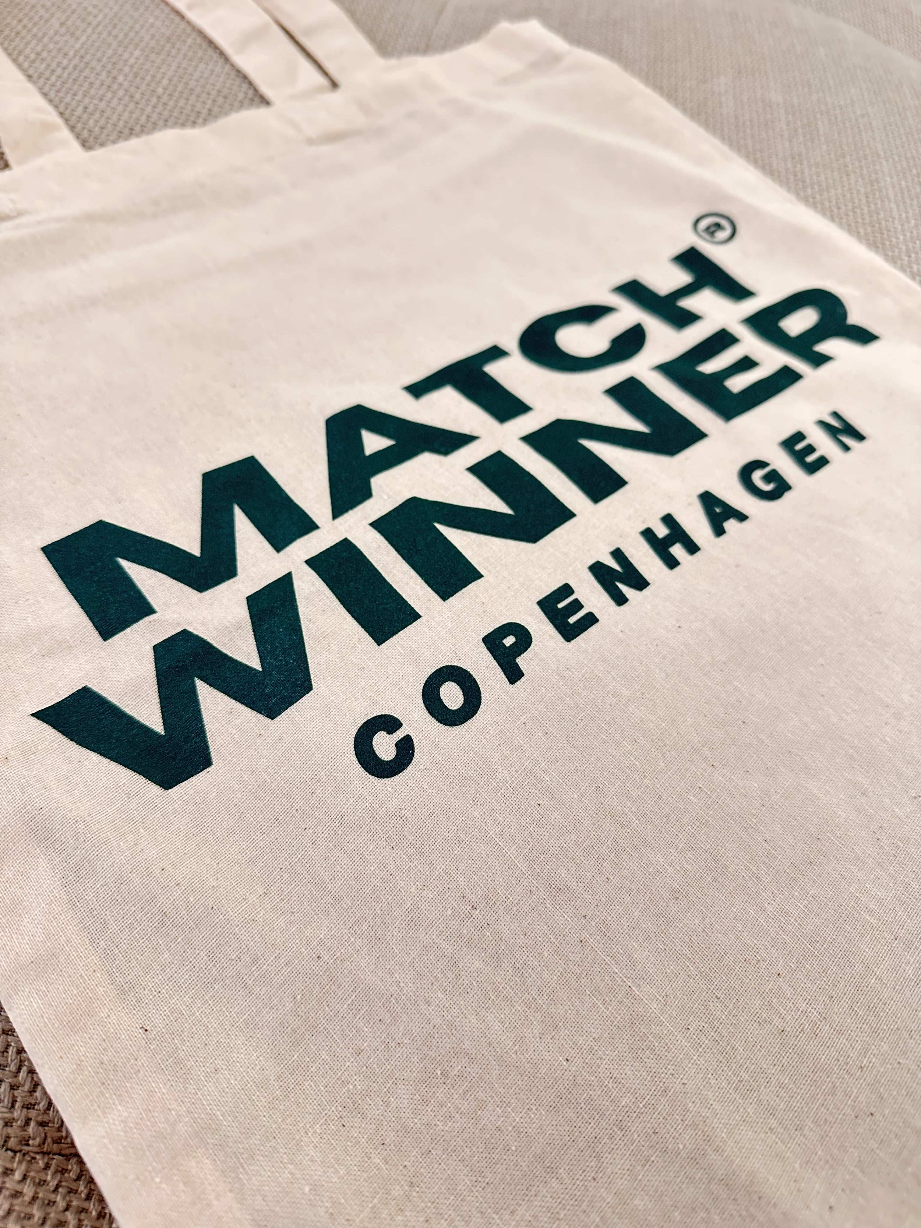 Nærbillede af MATCHWINNER COPENHAGEN logo på en stilfuld TOTEBAG