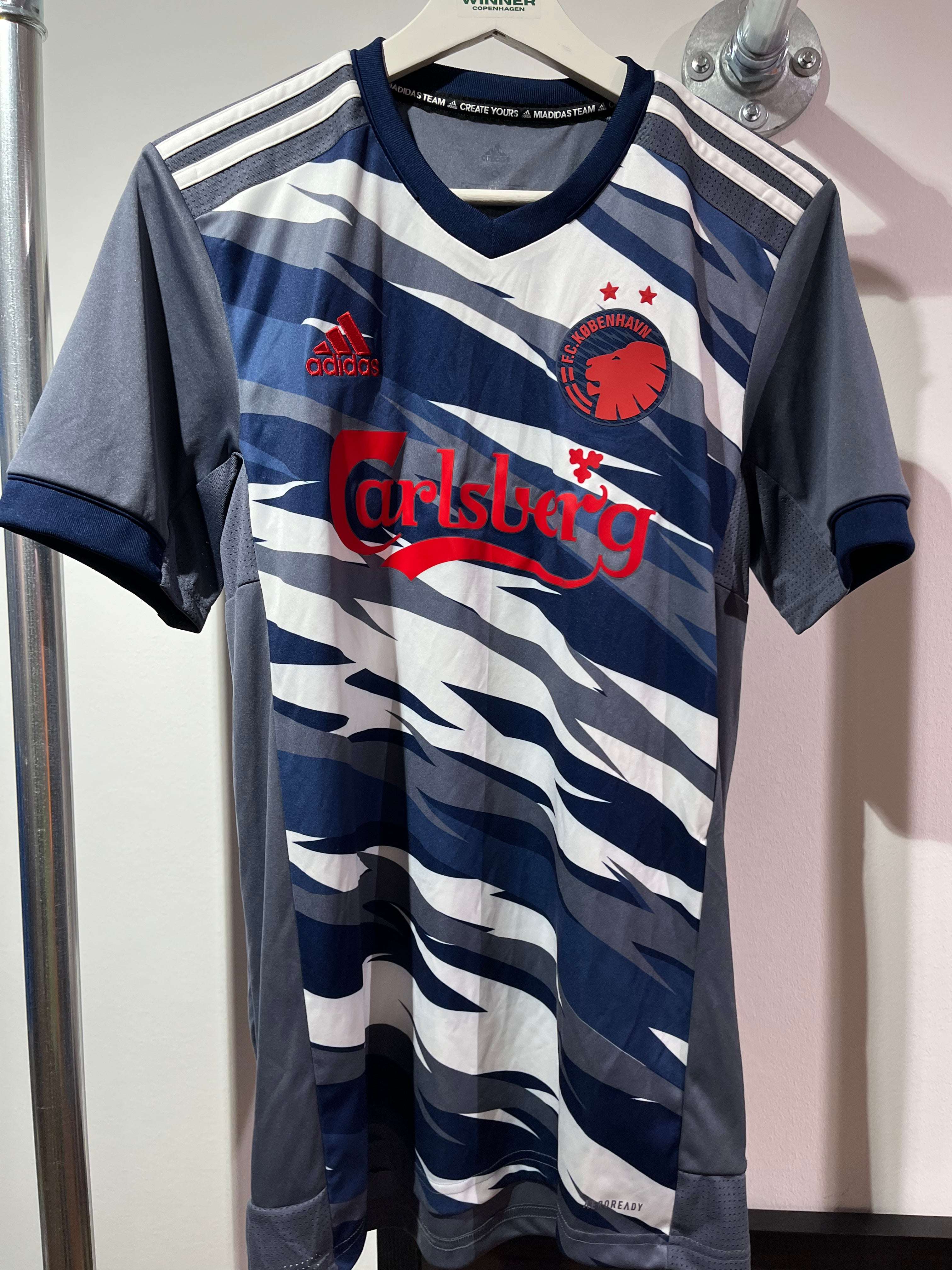 Fronten af den camouflage-mønstrede FCK 3. Trøje 2020/21 S med det røde klublogo.